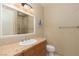 Bathroom featuring a granite countertop, wood cabinets, decorative mirror, and glass-enclosed shower at 6 Via Vasari # 105, Henderson, NV 89011