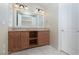 Bathroom with a double sink vanity, wood cabinets, and an oversized mirror at 6 Via Vasari # 105, Henderson, NV 89011