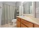 Clean bathroom featuring a shower with curtain, wood vanity, and tile flooring at 640 Finch Island Ave, Henderson, NV 89015