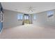 Spacious bedroom with neutral carpet, ceiling fan, and view from windows and sliding doors at 640 Finch Island Ave, Henderson, NV 89015