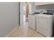 Tiled laundry room includes new white front-load washer and dryer units at 640 Finch Island Ave, Henderson, NV 89015