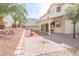 Lush backyard with a covered patio, mature trees, and a brick walkway at 6630 Cave Rock Ave, Las Vegas, NV 89110