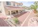 A backyard with a red-tiled covered patio, a built-in barbecue, and desert landscaping at 6630 Cave Rock Ave, Las Vegas, NV 89110