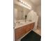 Bathroom featuring a double vanity, neutral countertops, and a large mirror at 6630 Cave Rock Ave, Las Vegas, NV 89110