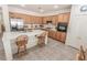 Classic kitchen with wood cabinets, stainless steel appliances, central island with seating and tile flooring at 6630 Cave Rock Ave, Las Vegas, NV 89110