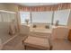Main bathroom boasting a large tub, separate shower, window with blinds, and a cozy bench at 6630 Cave Rock Ave, Las Vegas, NV 89110