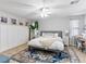 Cozy bedroom with a ceiling fan, white walls, wood floors, and a plush rug at 817 Great Sky Ct, North Las Vegas, NV 89084