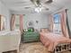 Charming bedroom with a crib, twin bed, ceiling fan, and a large window at 817 Great Sky Ct, North Las Vegas, NV 89084