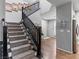 Beautiful staircase with carpeted steps, black railing, and decorative wall hangings and access to the kitchen at 817 Great Sky Ct, North Las Vegas, NV 89084