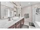 Elegant bathroom featuring double sinks, frameless shower, and soaking tub at 8507 Insignia Ave # 102, Las Vegas, NV 89178