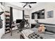 Cozy bedroom setup featuring bed, shelves, gaming desk, and ceiling fan at 8507 Insignia Ave # 102, Las Vegas, NV 89178