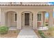 Inviting front porch with an arched entryway, dark brown front door, and a cozy seating area at 8507 Insignia Ave # 102, Las Vegas, NV 89178