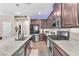 Gourmet kitchen with granite countertops, stainless steel appliances, and dark wood cabinetry at 8507 Insignia Ave # 102, Las Vegas, NV 89178