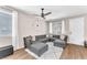 Bright living room with a large gray sectional sofa, a ceiling fan, and natural light from windows at 8507 Insignia Ave # 102, Las Vegas, NV 89178