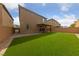 A backyard features an outdoor living space with a covered patio, brick perimeter, and a well-manicured lawn at 8675 Principato St, Las Vegas, NV 89166