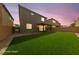 Beautiful backyard with lush grass, a covered patio, and a view of the home's exterior at 8675 Principato St, Las Vegas, NV 89166
