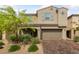 Inviting home exterior showcasing a brick driveway, a two-car garage, and lush landscaping at 8675 Principato St, Las Vegas, NV 89166