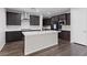 Modern kitchen with an island, stainless steel appliances, dark cabinets, and hardwood flooring at 8675 Principato St, Las Vegas, NV 89166