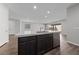 Modern kitchen island features a stainless steel sink, dishwasher, and sleek, dark cabinetry with a white countertop at 8675 Principato St, Las Vegas, NV 89166