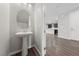 Charming powder room featuring a pedestal sink and a view into an open-concept living space at 8675 Principato St, Las Vegas, NV 89166