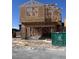 New two story home under construction with wood framework and open garage on a sunny day at 9076 Rivington Ave, Las Vegas, NV 89148
