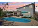 A pool is surrounded by desert landscaping with a covered patio set up for relaxation at 9625 W Meranto Ave, Las Vegas, NV 89178