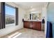 Bathroom with double vanity, large mirror and natural lighting at 9625 W Meranto Ave, Las Vegas, NV 89178