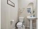Powder room features pedestal sink, toilet and decorative mirror at 9625 W Meranto Ave, Las Vegas, NV 89178