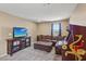 Versatile bonus room with plush carpet, a large sectional sofa, and modern electronic appliances at 9625 W Meranto Ave, Las Vegas, NV 89178