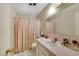 A retro bathroom with a pink tile sink, toilet, shower and an enclosed shower at 1041 E Saint Louis Ave, Las Vegas, NV 89104