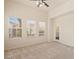 Bright bedroom with neutral carpet, multiple windows, and a ceiling fan for optimal comfort at 10550 W Alexander Rd # 2017, Las Vegas, NV 89129