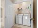 Small laundry room features newer model washer and dryer, shelving and white door at 10550 W Alexander Rd # 2017, Las Vegas, NV 89129