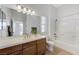 Bright bathroom featuring a single vanity, tiled shower-tub, and a large mirror reflecting natural light at 1264 Olivia Pkwy, Henderson, NV 89011