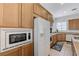 Close-up of kitchen with built-in microwave, oven, and refrigerator, complemented by light wood cabinets at 1264 Olivia Pkwy, Henderson, NV 89011