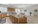 Granite kitchen island with a built-in cooktop, sink, bar seating and view into the dining area at 1264 Olivia Pkwy, Henderson, NV 89011