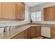 Kitchen area with granite countertops, wooden cabinets, and a stainless steel sink under a bright window at 1264 Olivia Pkwy, Henderson, NV 89011