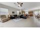 Open-concept living room showcasing tiled floors, a ceiling fan, and seamless flow to the kitchen and dining area at 1264 Olivia Pkwy, Henderson, NV 89011