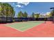 Outdoor tennis court with a net, surrounded by a fence and mature trees at 1264 Olivia Pkwy, Henderson, NV 89011