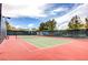 Outdoor tennis court featuring a net and surrounded by a fence and lush landscaping at 1264 Olivia Pkwy, Henderson, NV 89011