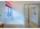 Bathroom featuring a tub, glass enclosed shower, and decorative window at 1309 Misty View Ct, North Las Vegas, NV 89031