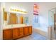 Primary bathroom featuring double sinks, vanity lighting and combination tub and shower at 1309 Misty View Ct, North Las Vegas, NV 89031