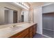 Bathroom featuring double sinks, cabinets, a large mirror, and an adjacent walk-in closet at 1335 Heather Oaks Way, North Las Vegas, NV 89031