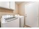 Laundry room with front loading washer and dryer, storage cabinets, and exterior access at 1335 Heather Oaks Way, North Las Vegas, NV 89031
