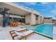 Inviting backyard featuring a pool, outdoor seating, dining area and lush greenery, ideal for relaxation and entertaining at 144 Tre Pietre St, Henderson, NV 89011
