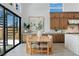 Bright dining area connected to a gourmet kitchen and featuring an adjacent spiral staircase and large picture window at 144 Tre Pietre St, Henderson, NV 89011