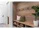 Mud room with hooks, built-in bench, storage shelves and natural wood accent wall at 144 Tre Pietre St, Henderson, NV 89011