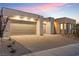 Elegant home with a three-car garage, modern design, and attractive landscaping enhancing its curb appeal in twilight at 144 Tre Pietre St, Henderson, NV 89011