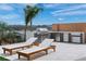 Well-equipped outdoor kitchen with a built-in grill, sink, and lounging chairs for cooking and relaxing by the pool at 144 Tre Pietre St, Henderson, NV 89011