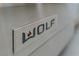 Close up of the stainless steel Wolf brand badge and logo on the front of a professional range at 144 Tre Pietre St, Henderson, NV 89011