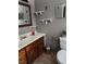 A traditional bathroom featuring a white toilet, a wood vanity, and decorative mirrors at 1812 Ivanhoe Way, Las Vegas, NV 89102